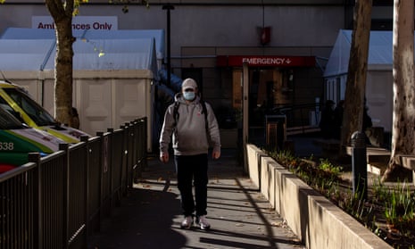A man wears a face mask as he walks out from a hospital