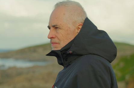 Head and shoulders shot of Jackson in jacket looking out to sea