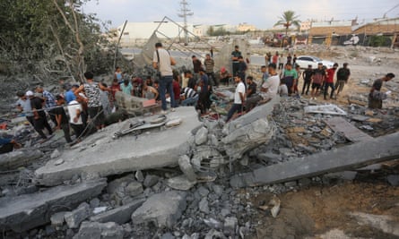 People standing amid the rubble of a destroyed building.