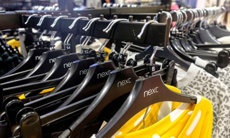 Garments on coat hangers are pictured at a Next store in London