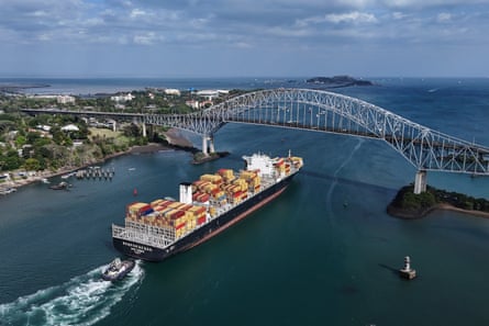 A cargo ship sails under Las Americas bridge through the Panama Canal.