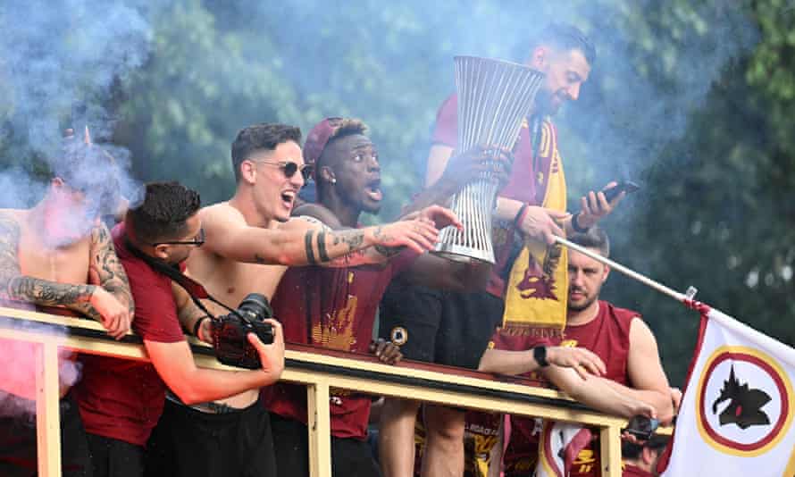 Roma's Tammy Abraham celebrates the European Conference League Cup on a bus.