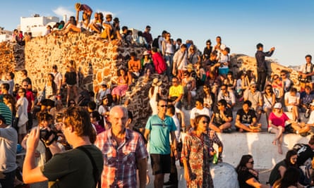 Tourists gather to watch the sunset in Santorini