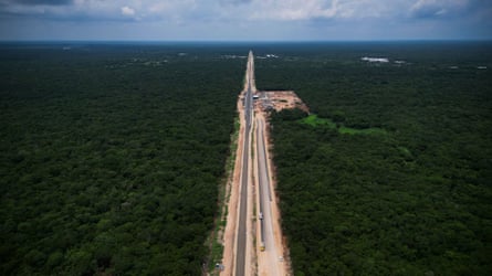 An aerial view of train tracks cutting through a green landscape