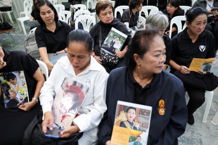 Rows of women on plastic chairs holding photos of the princess