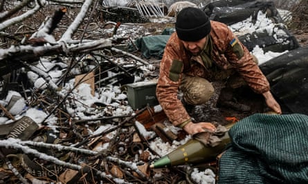 A Ukrainian serviceman cleans a shell for an M777 howitzer at the frontline in Donetsk