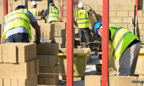 Builders constructing new houses out of brick on a building site