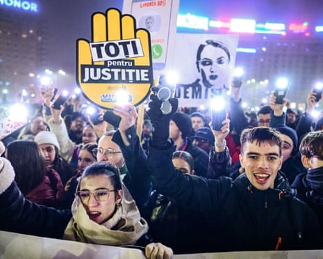 A man holds a placard reading 'All for the Justice' during a protest in the front of the Romanian government headquarters in Bucharest