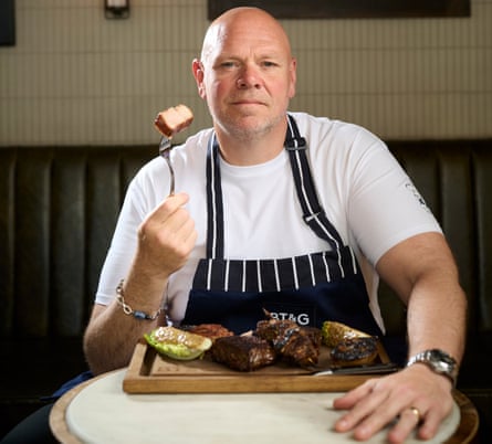 A chef holds up some food on his fork.