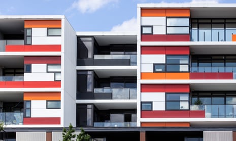 The front of an apartment building with white, red and orange cladding