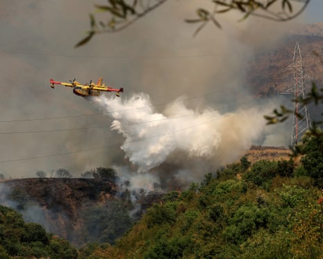 An Italian Canadair CL-415 aircraft drops liquid over a wildfire near the town of Delvine, southeast Albania.
