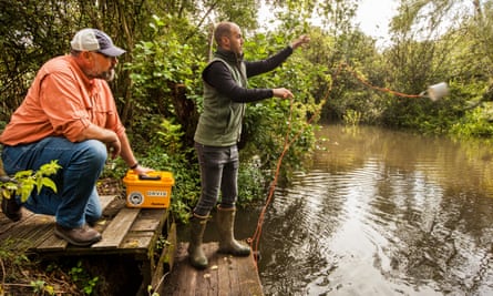 Richard Maude collecting a water sample for analysis watched by Kris Kent from the Angling Trust.