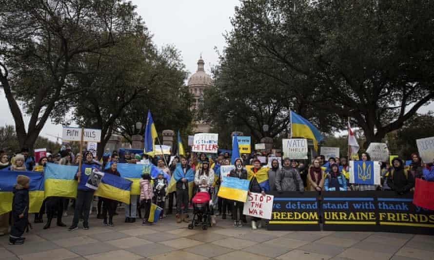 Group of people standing with yellow and blue flags and posters