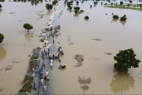 People walk through flood water after heavy rainfall in Hadeja, Nigeria, on 19 September