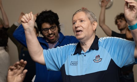 Brian Ward singing with arms raised.