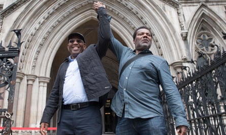 Paul Green (left) and Cleveland Davidson holding up joined hands outside the royal courts of justice