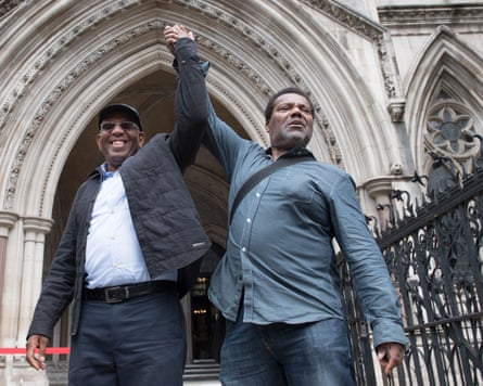 they have their arms raised and hands held together in victory