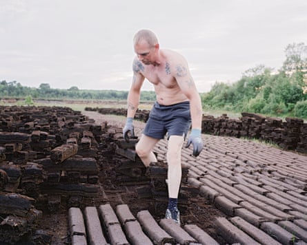 A man cutting turf in a field