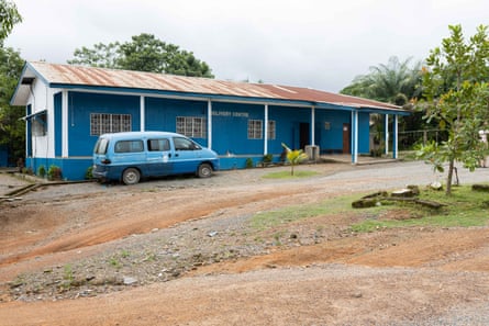 A van parked outside a blue single story building in a rural setting