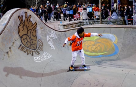 man on skateboard at skate park with crowd in background