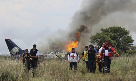 Red Cross and rescue workers carry an injured person from the site where an Aeromexico airliner crashed in a field near the airport in Durango, Mexico