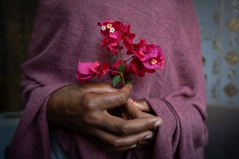 A woman’s hands holding a spray of pink flowers.