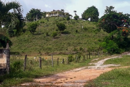 a house sits atop a grassy hill