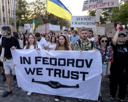 Young people march behind a white banner with the words 'In Fedorov we trust'