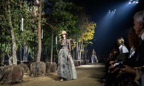 A fashion show takes place among trees.
