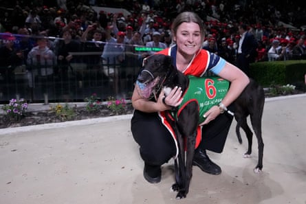 A woman embracing a greyhound