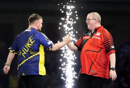 Luke Littler (left) shakes hands with Stephen Bunting after winning their semi-final match at the world championship at Alexandra Palace in January 2025