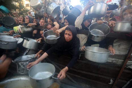 A charity distributes meals to Palestinian people facing extreme food shortages in Gaza City.
