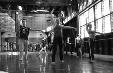 A black and white photograph depicts three dancers rehearsing in a studio