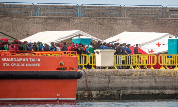 People rescued from different boats remain in the port of Arguineguín on the island of Gran Canaria, while being cared for by police and the Spanish Red Cross.