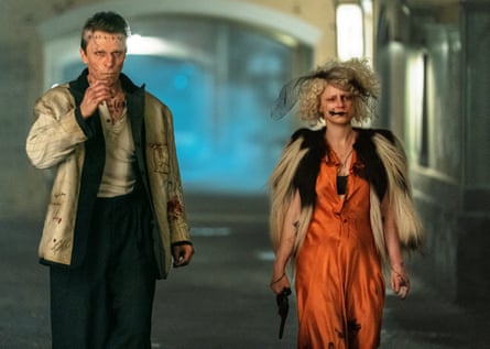 A man dressed as Frankenstein and a woman dressed in a long tangerine-coloured dress with a cream and black furry stole