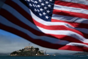 An American flag flies on a boat leaving Alcatraz Island