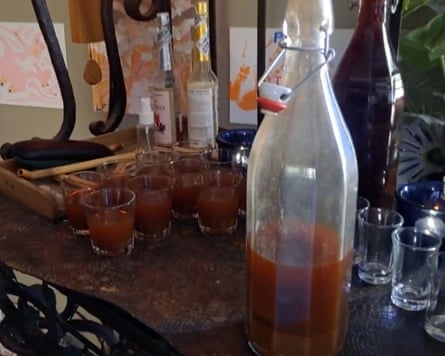 A red liquid in a bottle, which has been poured into several glasses
