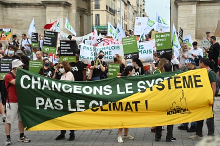 A man holds a banner reading 'Change the system not the climate'
