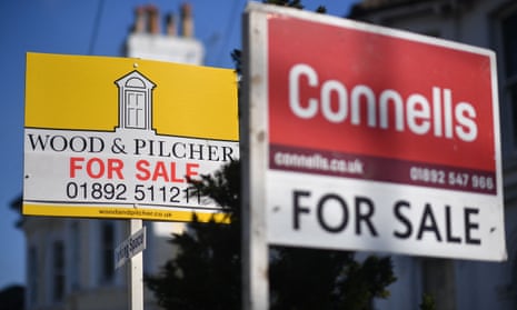 For Sale signs are seen on a residential street in Tunbridge Wells, Kent