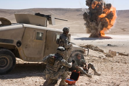 US soldiers in the desert look at an explosion