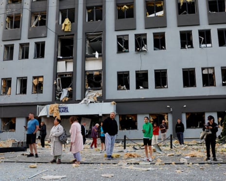 People stand at the site of a building housing the local branch of the British Council after it was hit by Russian missile and drone strikes.