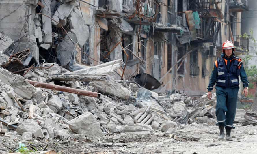 A member of Russia’s Emergencies Ministry walks near a residential building on 11 May, destroyed since Russia’s invasion of Ukraine.