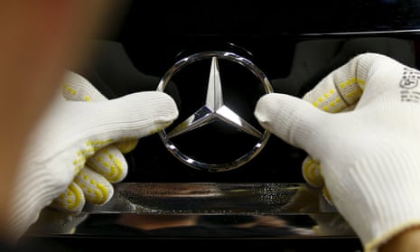 mercedes badge being put on a car by a human