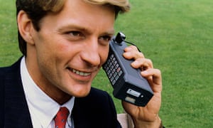 uno yuppie degli anni '80 su un enorme telefono cellulare