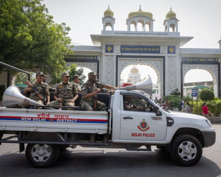 Police patrol the streets of Delhi on the back of a pickup truck.