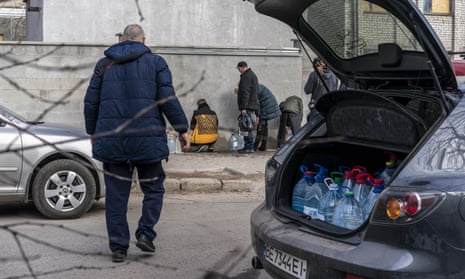 People fill water bottles in Mykolaiv