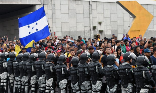 The Mexican National Guard looks on as migrants from Central and South America take part in a caravan towards the border with the US, Tapachula, Chiapas state, Mexico, on 6 June 2022.