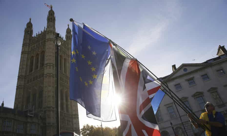 A man waves EU and UK flags outside the Houses of Parliament in London.