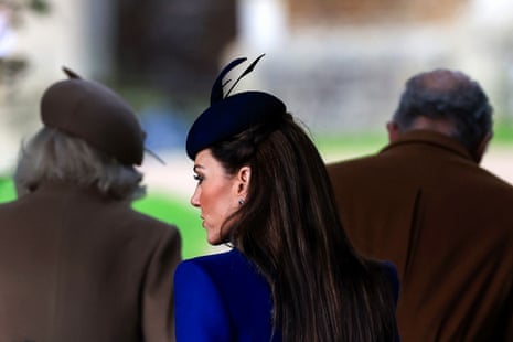 a woman in a blue coat and blue hat is seen from the back with her head turned sideways
