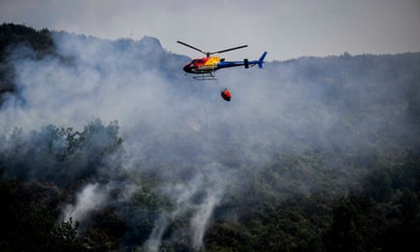 Firefighting helicopter overflying burning forest